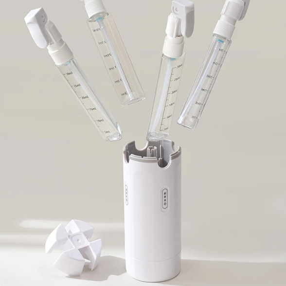 White handheld device with multiple spray nozzles on a light gray background